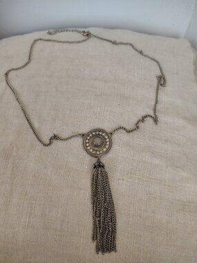 Silver tone Long chain necklace with a round metal pendant and rhinestone accent